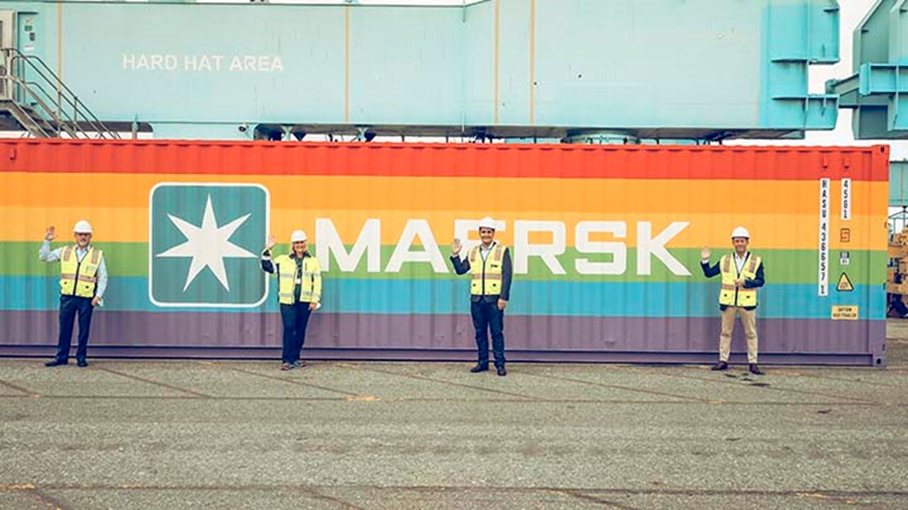 LGBTQi+ inclusion at workplace – Four Maersk employees in protective gears standing in front of the rainbow container.